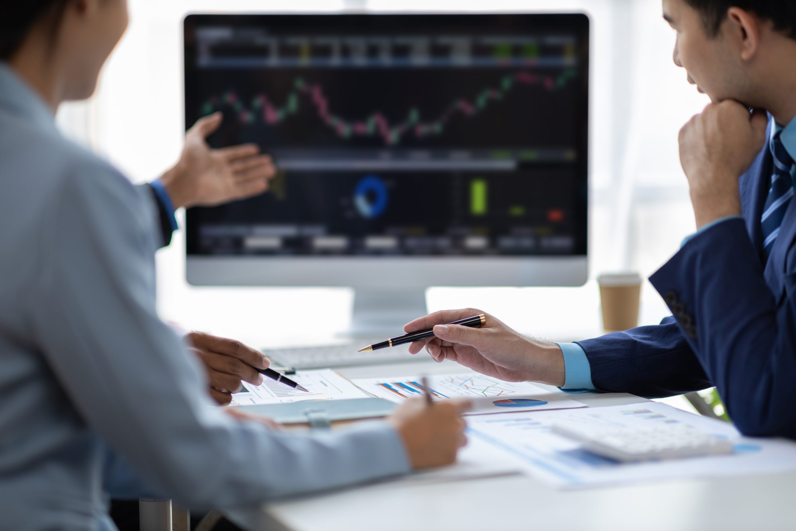Businessman meeting with consultants discussing data analysis, charts and graphs in financial reports to plan investments and increase company profits. Strategy analysis and business planning meeting.